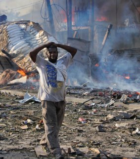 A man walks past destroyed buildings at the scene of a blast in Mogadishu, Somalia.