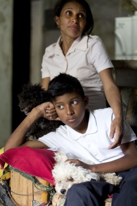 Roberto Bernal's widow Argelia Gamboa and her 11-year-old son Royber Fuentes sit in their home in a hillside slum in Caracas, Venezuela. 