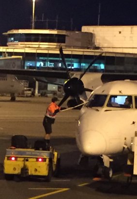A worker cleans a plane's windscreen at Brisbane Airport.