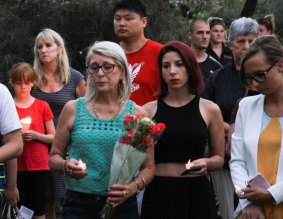 Residents and well-wishers pay their respects at a candelight vigil for Queenie Xu in a park across the road from where she was stabbed to death in Parkinson.