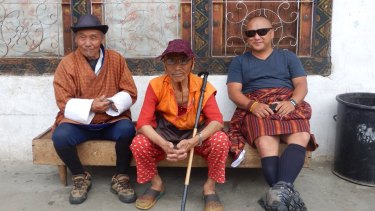 Men sit outside a house in downtown Paro, Bhutan.