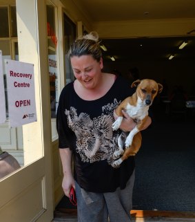 Jewelle Mulcahy at the Lancefield fires recovery centre on Thursday with her neighbour's dog Missy, rescued when Missy become stranded by roadblocks.