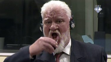 Slobodan Praljak brings a bottle of poison to his lips during a Yugoslav War Crimes Tribunal in The Hague.