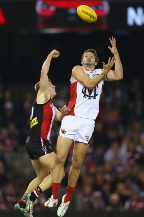 Melbourne's top goal-scorer Jesse Hogan leaps high for a mark in front of Jack Newnes of the Saints.
