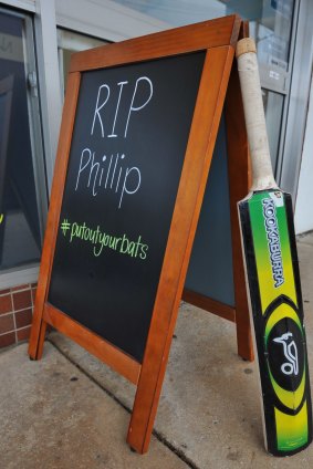A cricket bat and sign outside a cafe in Macksville as a sign of respect for Phillip Hughes.