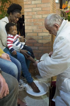 Pope Francis washes the feet of a prisoner's child at Rebibbia's jail in Rome. 