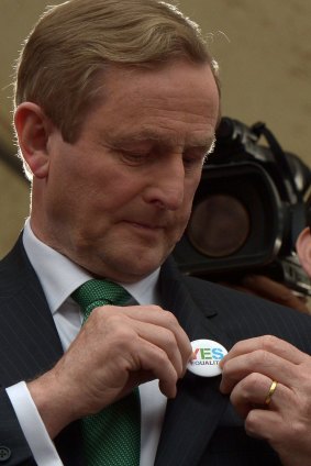 Irish Prime Minister Enda Kenny puts on a Yes vote campaign badge.