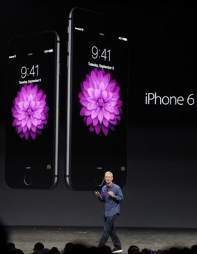 Apple chief executive Tim Cook showcasing the iPhone 6 and iPhone 6 Plus.