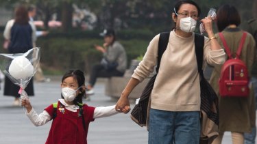 Health a risk: A woman and child wear masks during a hazy day in Beijing. 