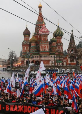 Russians carrying protest banners march in memory of assassinated opposition leader Boris Nemtsov. 
