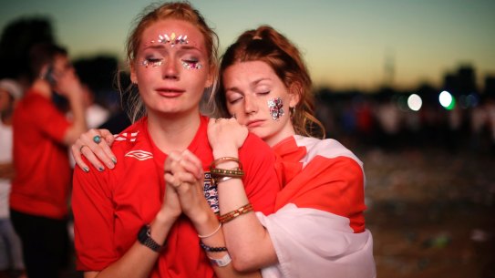 England soccer fans react after losing the semifinal match between Croatia and England at the 2018 soccer World Cup, in Hyde Park, London.