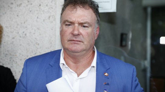 Rod Culleton, with his  Australian Senator pin on display, departs the High Court. 