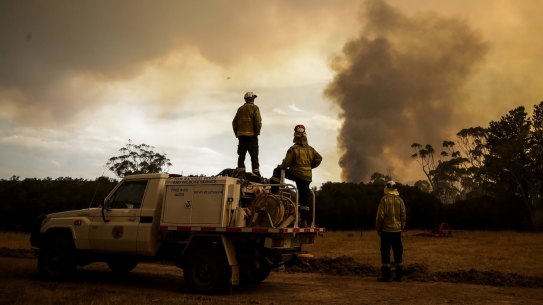 Fire crews work to defend Bombay resident Les Hart's property as the North Black Range bushfire approaches, seen near Bombay, NSW.