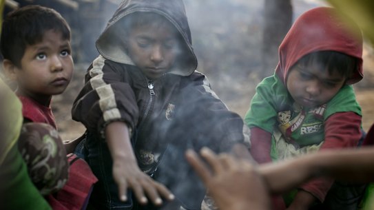 A family who fled violence in Salipara village in Myanmar sit at a Rohingya refugee camp in Bangladesh.