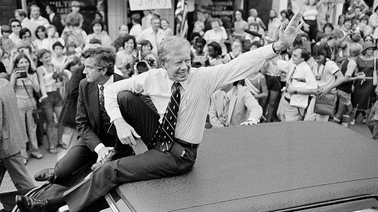 President Jimmy Carter waves from the roof of his car along the parade route through Bardstown, Kentucky.