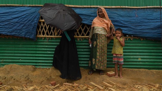 Rohingya women take shelter during a monsoonal downpour in Hakim Para Camp. The camps in Cox?s Bazar are home to over 900,000 Rohingya refugees that fled Myanmar in August last year. Cox?s Bazar, Bangladesh. 16th July, 2018. Photo: Kate Geraghty