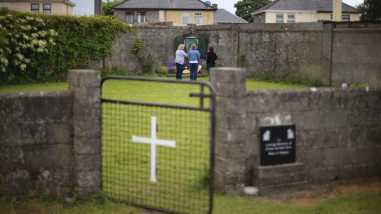 Members of the public gather in memory of the children buried here at the site of a mass grave for babies who died in the Tuam mother and baby home in Ireland.