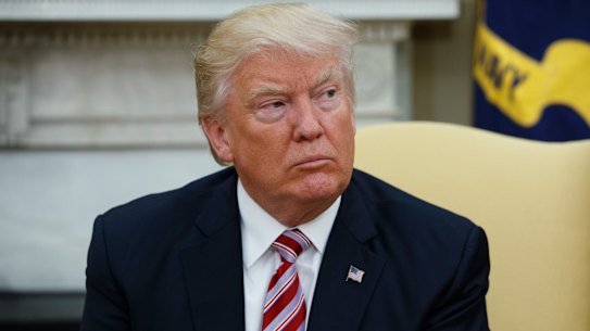 US President Donald Trump talks to reporters in the Oval Office.