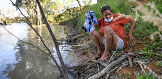 Catherine Bugmy from Wilcannia is currently in isolation at the Warrawong on the Darling after testing positive to COVID-19. She doesn't have access to a washing machine so is forced to do her washing in the the Darling River. Wilcannia, September 2, 2021. Photo: Rhett Wyman/SMH .