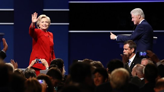 Hillary Clinton, 2016 Democratic presidential nominee, left, waves as former US president Bill Clinton gestures during the first presidential debate.