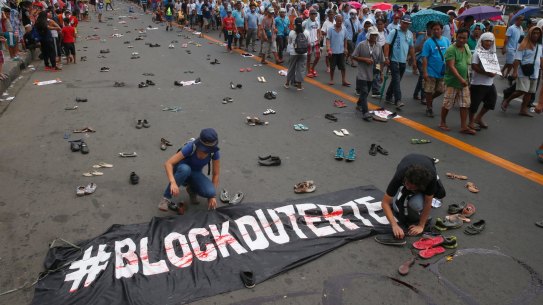 Protesters scatter pairs of slippers and shoes to symbolise victims of President Rodrigo Duterte's "war on drugs".