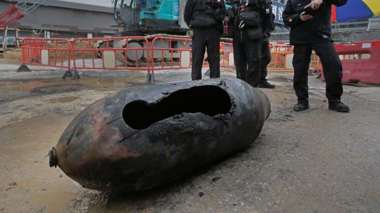 Police officers from explosive ordinance disposal stand next to the bomb at the scene in the Wan Chai district of Hong Kong.