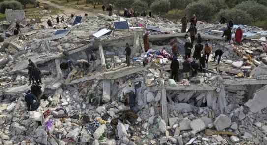 Civil defense workers and residents search through the rubble of collapsed buildings in the town of Harem near the Turkish border, Idlib province, Syria.