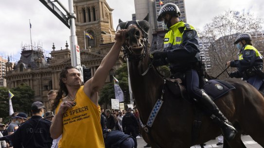 A man punches a Police Horse during an anti-lockdown rally in the CBD in Sydney 24 July, 2021. Photo: Brook Mitchell