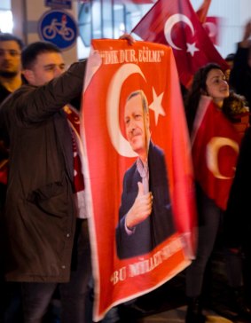 A demonstrator holds a poster of Turkish President Recep Tayyip Erdogan  outside the Turkish consulate in Rotterdam.