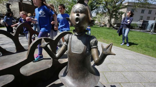 Children play near a bronze statue of a Dr Seuss character at the Dr Seuss National Memorial Sculpture Garden, in Springfield, Massachusetts. 