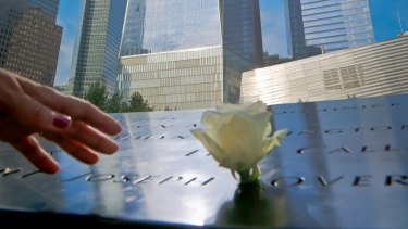A visitor reaches out to touch a name engraved on the September 11 memorial in New York.  