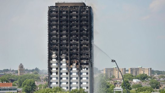 Firefighters spray water onto the 24-storey apartment block in west London on Wednesday.