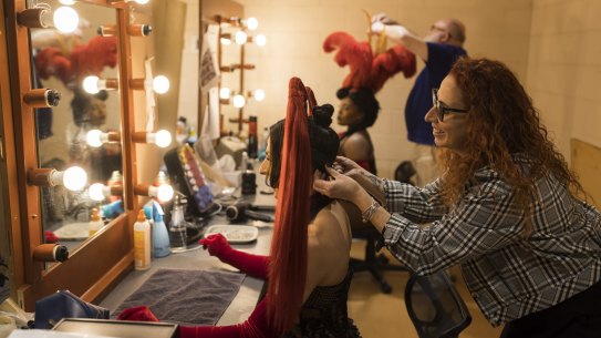 SAT NEWS. Wig, hair and makeup design associate Kylie Clarke and senior milliner Rick McGill with two performers, Chris Scalzo (pig-tail head-piece) and Ruva (feathered head-piece), who play Lady Marmalade in Moulin Rouge The Musical. Pictured backstage in the Wig room of the Capitol Theatre on June 1, 2022. Photo by Anna Kucera.