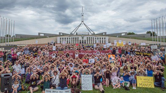 Protesters at Parliament House in Canberra cross their arms in solidarity with the Manus Island detainees.
