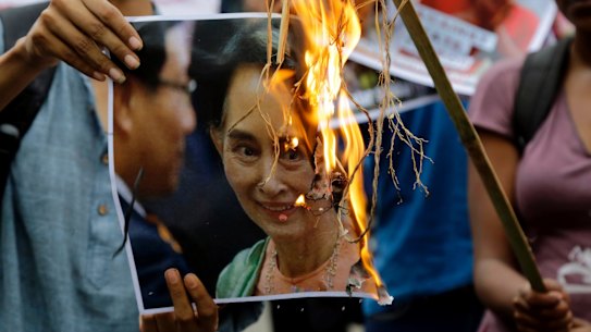 Reputation going up in flames: activists burn a poster of Aung San Suu Kyi.