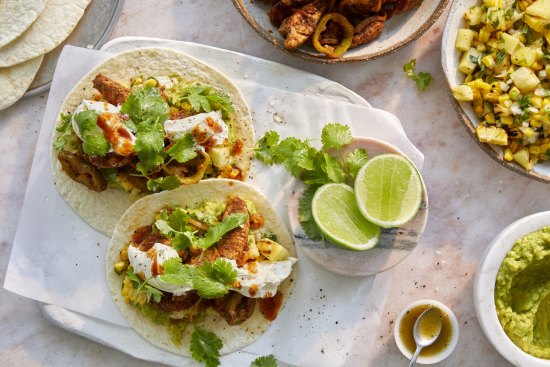 Hands-on feasting: Pork fajitas with pineapple and corn salsa, guacamole and sour cream.