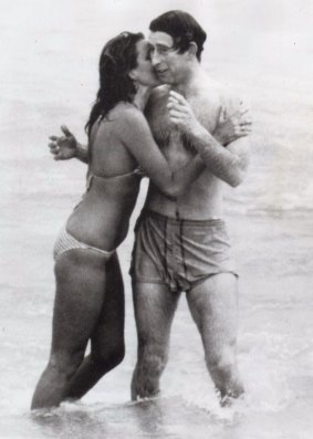 Prince Charles is kissed by Perth model Jane Priest while surfing at Cottesloe.