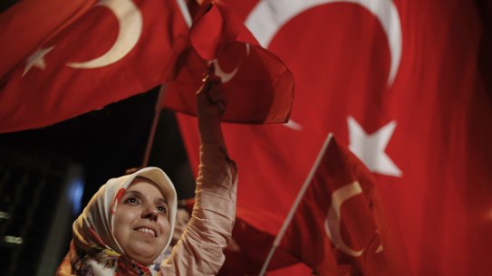 A woman waves Turkish flags during a rally against the attempted coup in Istanbul on Monday.