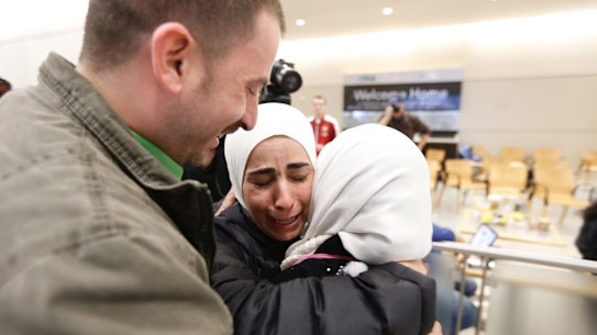 Hisham, left, and Mariam Yasin, centre, welcome their mother Najah al-Shamieh, from Syria, after immigration authorities released her at Dallas-Fort Worth Airport on Saturday.