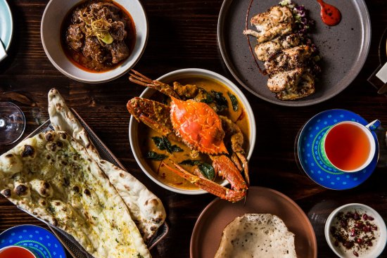 Clockwise from top left: Laal maas (meat curry), pepperberry chicken, nandu kuzhambu (crab curry), appam, garlic naan.