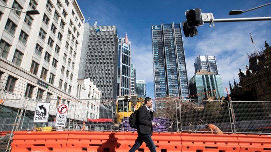 A man walks past the construction of the light rail at the intersection of George Street and Park Street, Sydney.