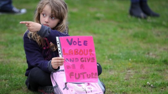 A young girl holds a sign supporting the Labour party.