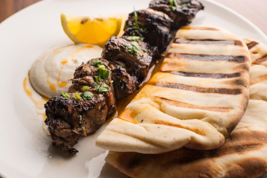 Skewered lamb rump with grilled flatbread and a squeeze of lemon.