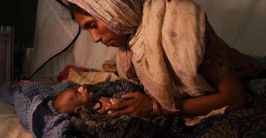 Rohingya woman Laila Begum holds her son Mohammed Ifran's hand as he receives treatment at the Red Cross Field Hospital in Kutupalong refugee camp.