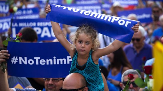 A young girl holds a sign reading "We are not afraid" in the Catalan language during a demonstration condemning the attacks that killed 15 people in Barcelona.