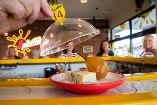 Cheeses trundle by on colour- and price-coded plates.