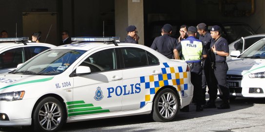 Police officers wait at the forensic department entrance at a hospital in Putrajaya, Malaysia, where Kim Jong-nam's body was taken. 
