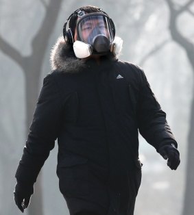 A man wearing a mask for protection against pollution exercise at Ritan Park during a heavily polluted day in Beijing.