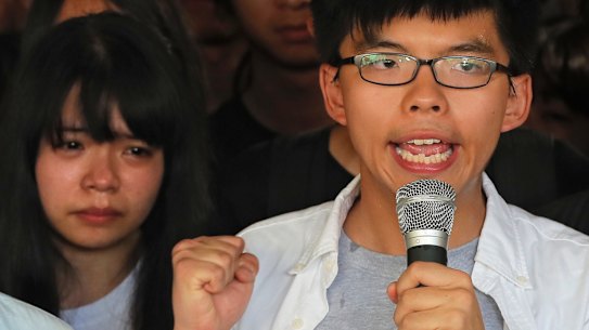 Joshua Wong, right, chants slogans as a supporter, left, reacts outside the high court before a ruling on a prosecution request for stiffer sentences in Hong Kong on Thursday.