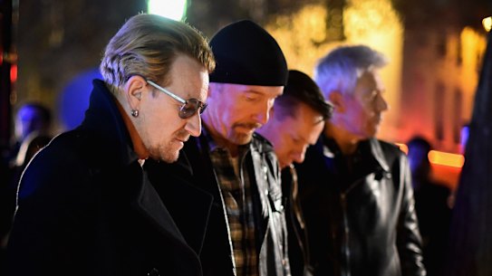 Bono and band members of U2 pay their respects and place flowers on the pavement near Bataclan Concert Hall.